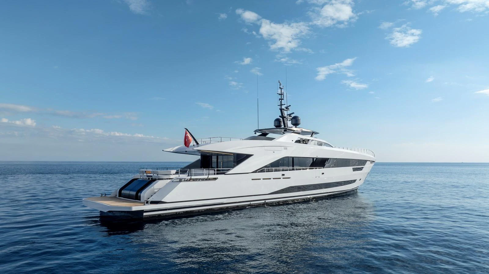 A sleek and modern yacht glides gracefully on calm waters under a clear blue sky. aboard XIMENA Yacht for Sale