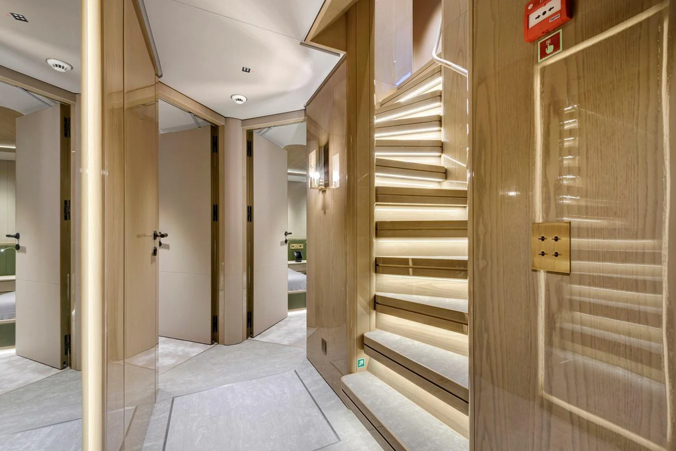 The interior features a beautifully lit staircase with elegant wood paneling and modern design elements. aboard XIMENA Yacht for Sale