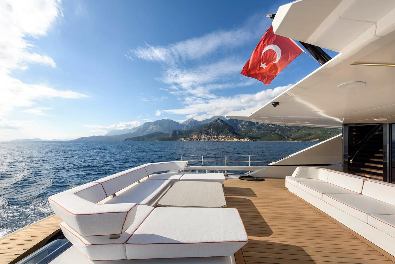 The aft deck offers a spacious and luxurious lounging area with stunning views of the sea and coastline. aboard XIMENA Yacht for Sale