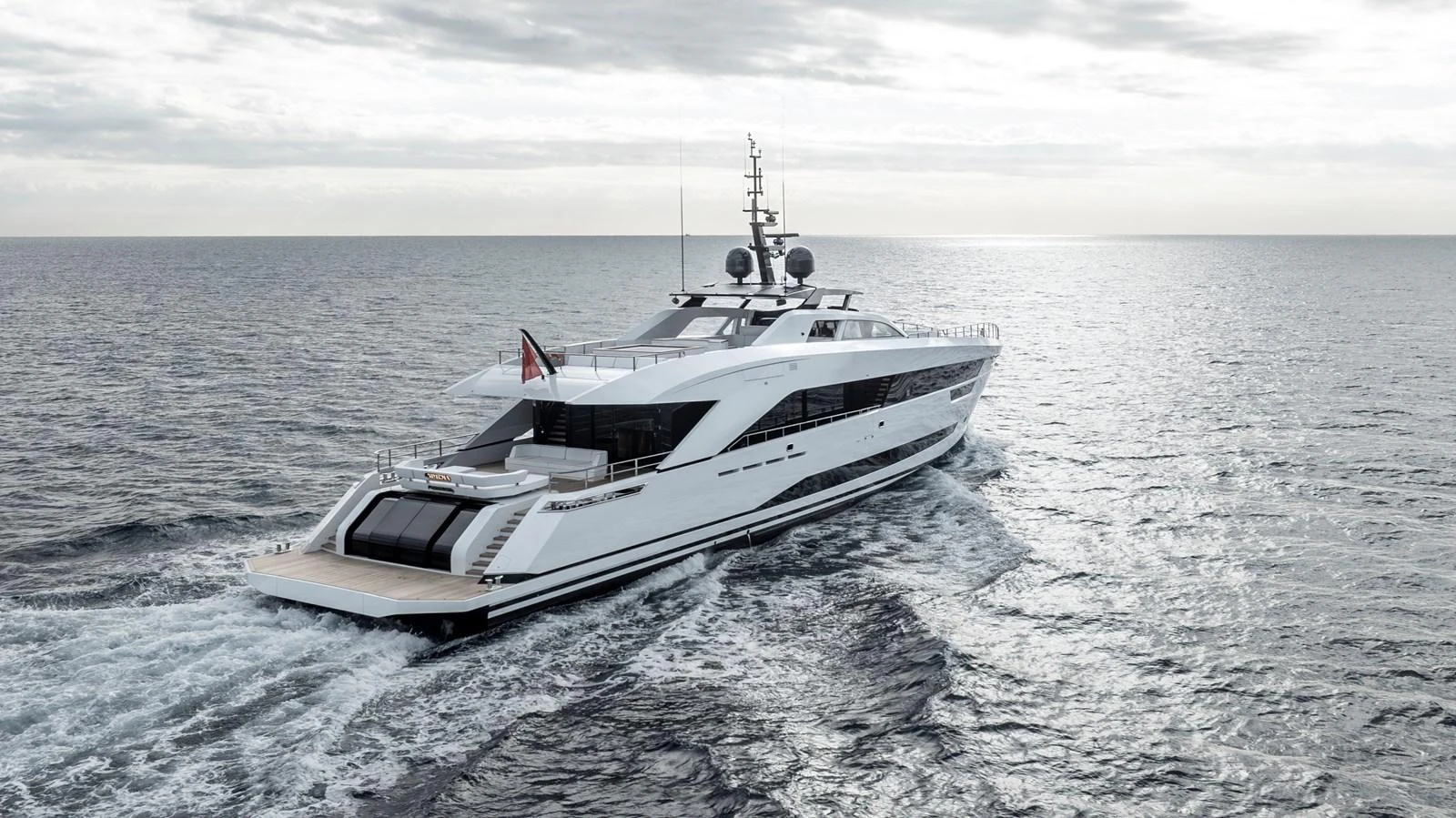 A sleek and modern yacht cruises through open waters, showcasing its elegant design and spacious aft deck. aboard XIMENA Yacht for Sale