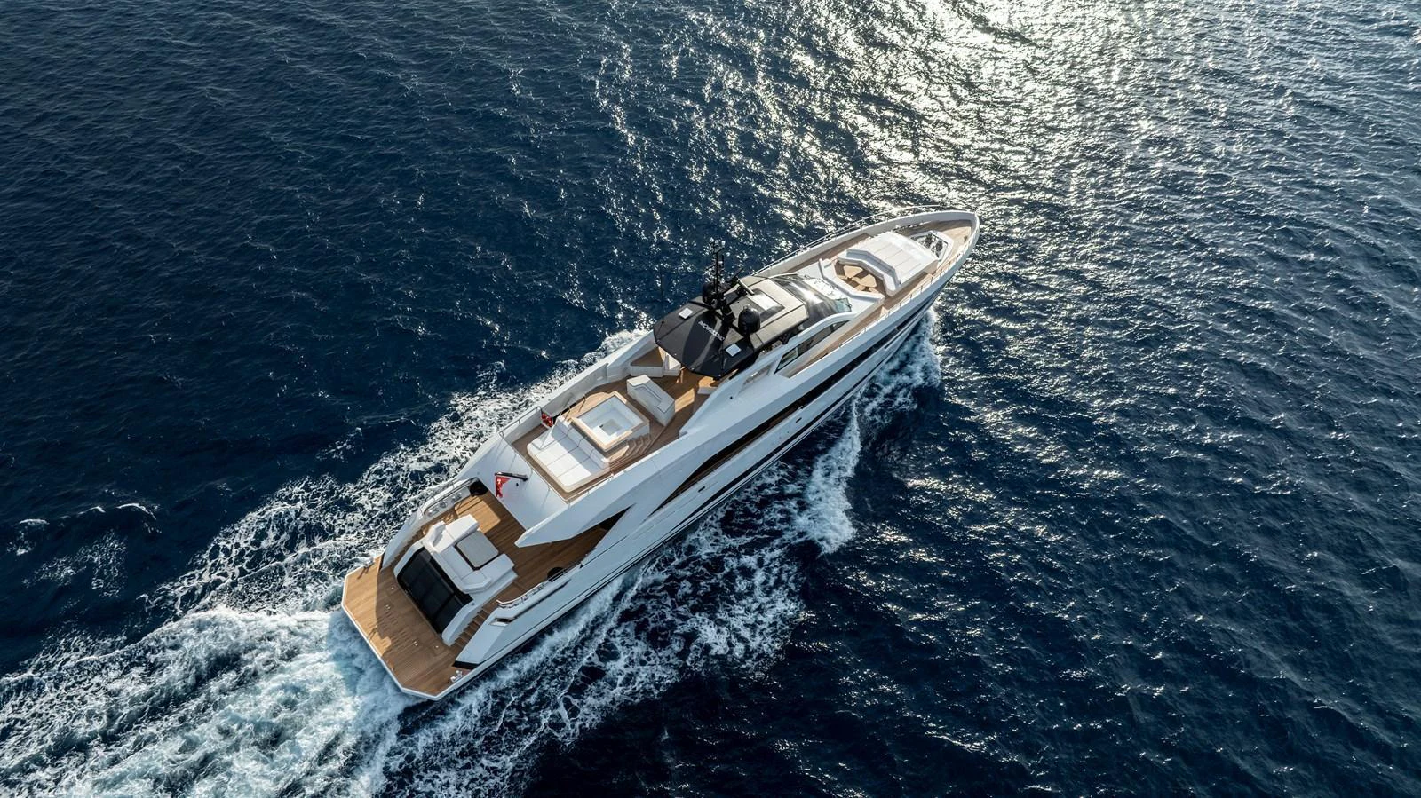 A sleek and modern yacht cruises through the open sea, showcasing its elegant design and spacious deck areas. aboard XIMENA Yacht for Sale