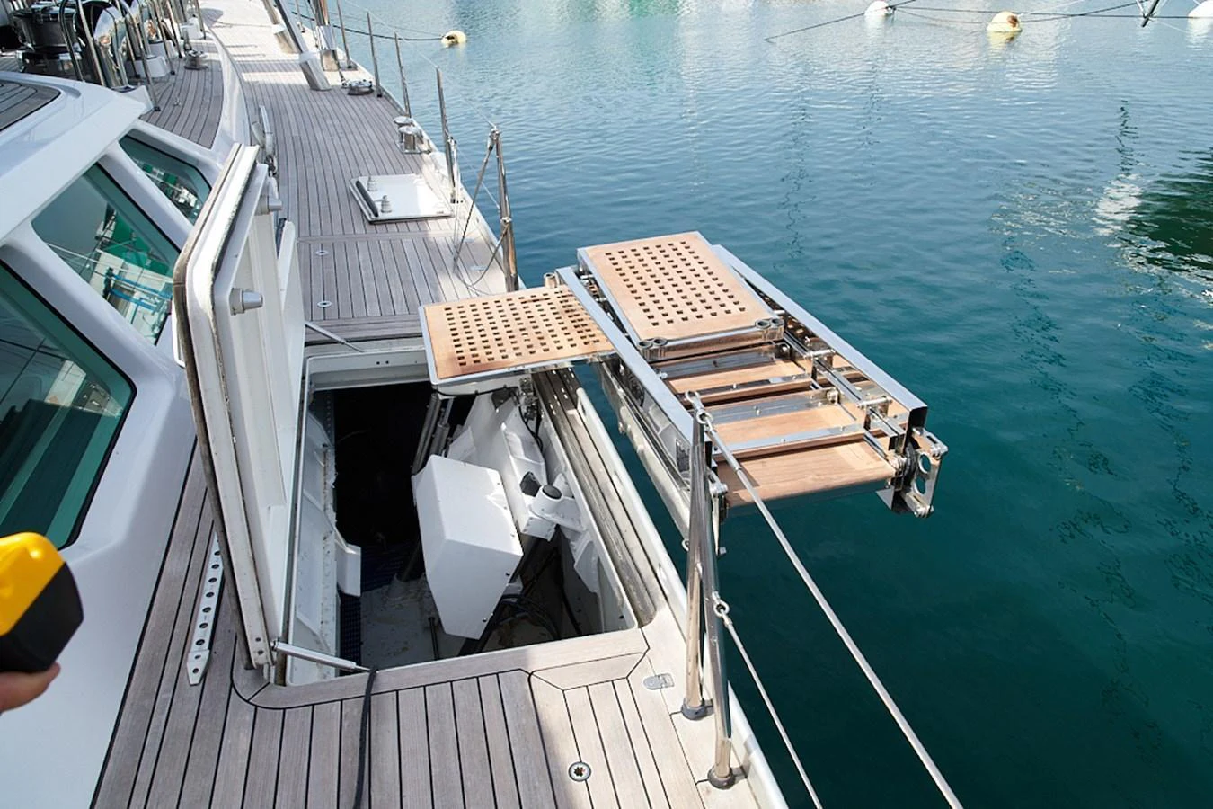 A detailed view of a yacht's boarding ladder and deck area, showcasing the craftsmanship and functionality. aboard CYCLOS III Yacht for Sale
