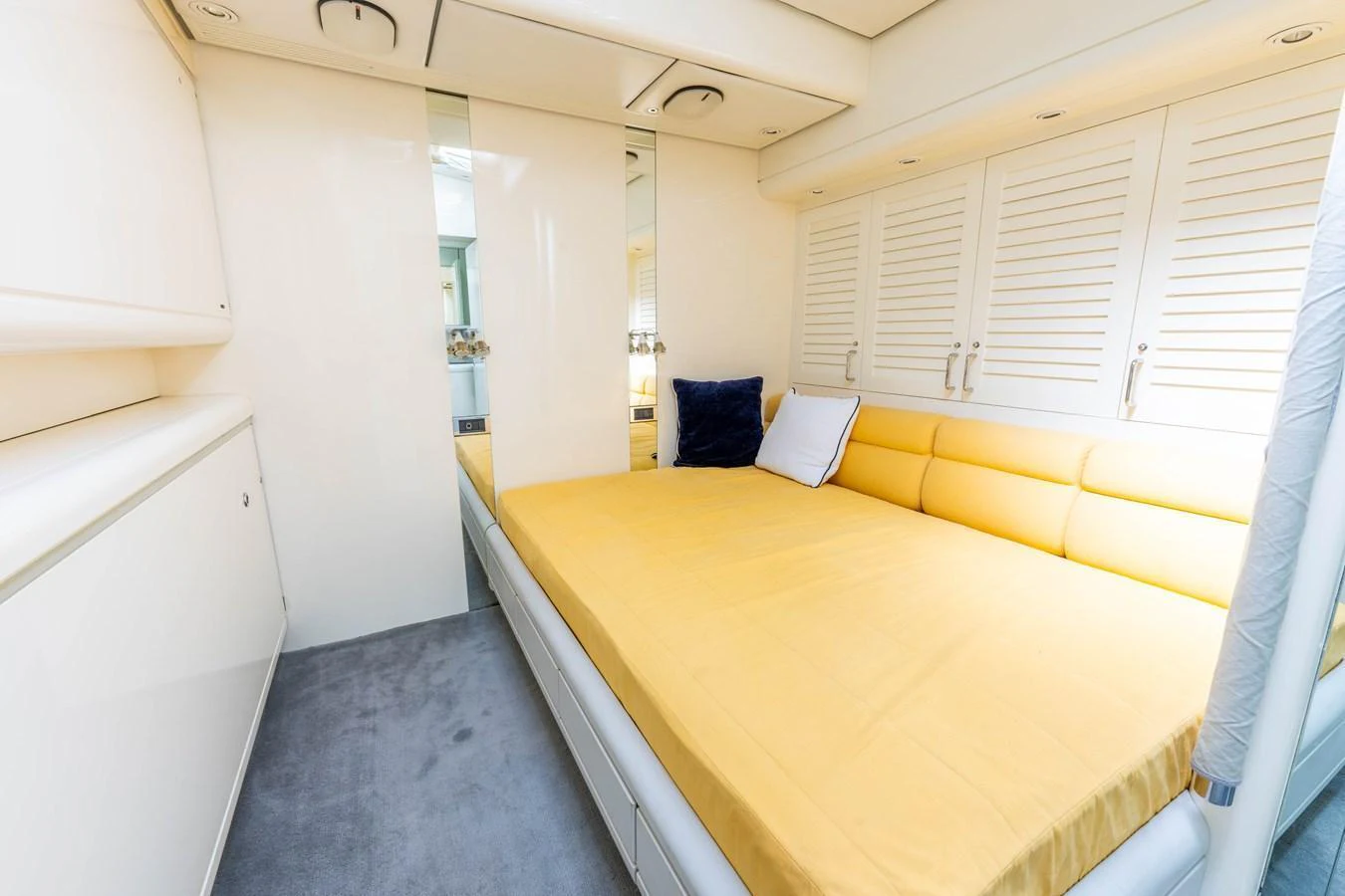 The stateroom features a comfortable bed with bright yellow bedding and ample storage space. aboard CYCLOS III Yacht for Sale