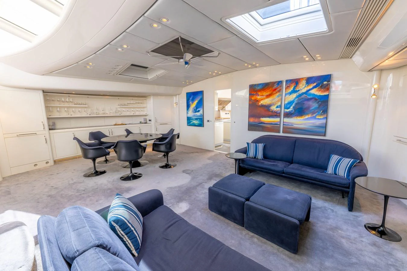 The salon features plush seating, modern decor, and ample natural light from overhead skylights. aboard CYCLOS III Yacht for Sale