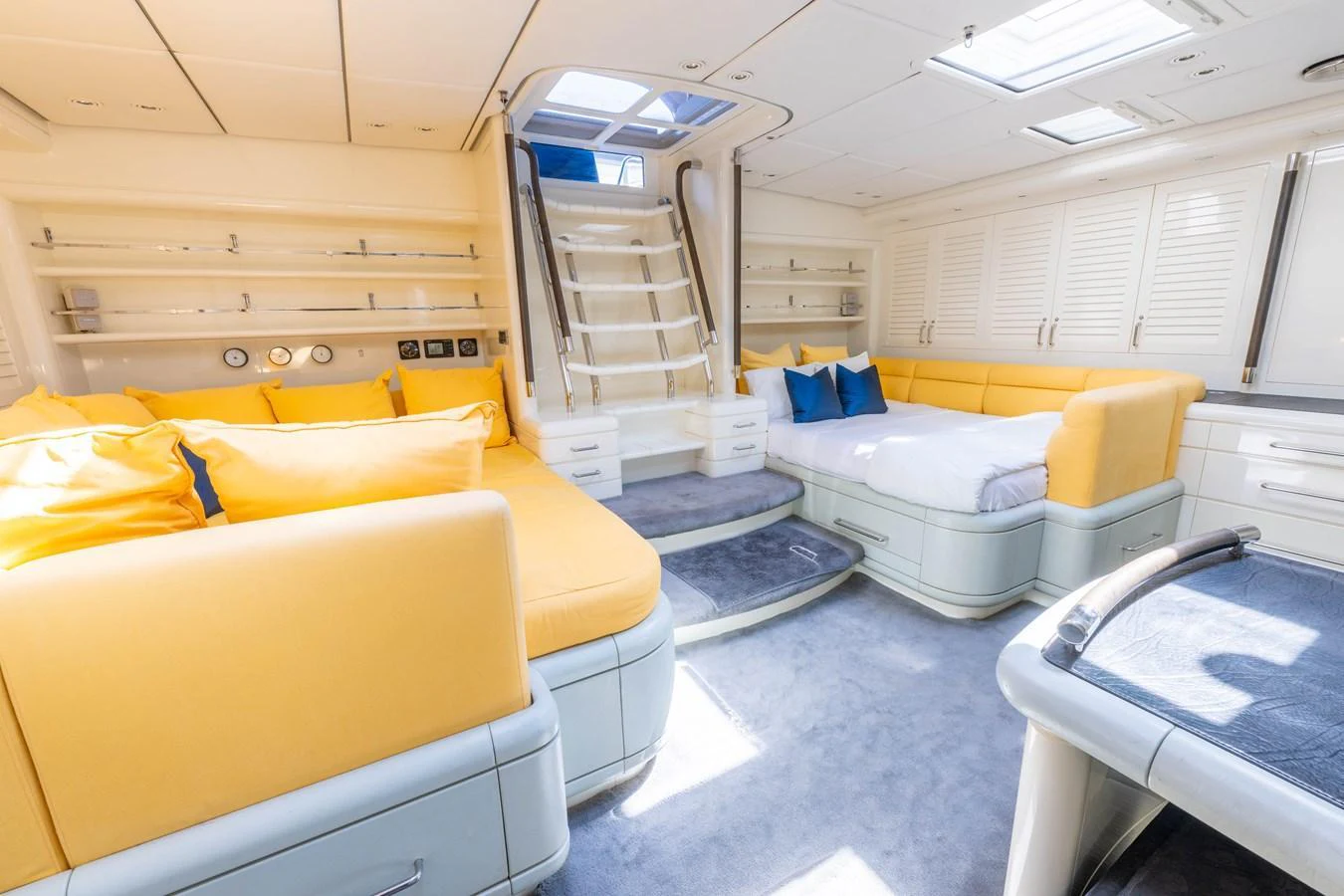 The salon features plush seating with vibrant yellow cushions, creating a bright and inviting atmosphere. aboard CYCLOS III Yacht for Sale