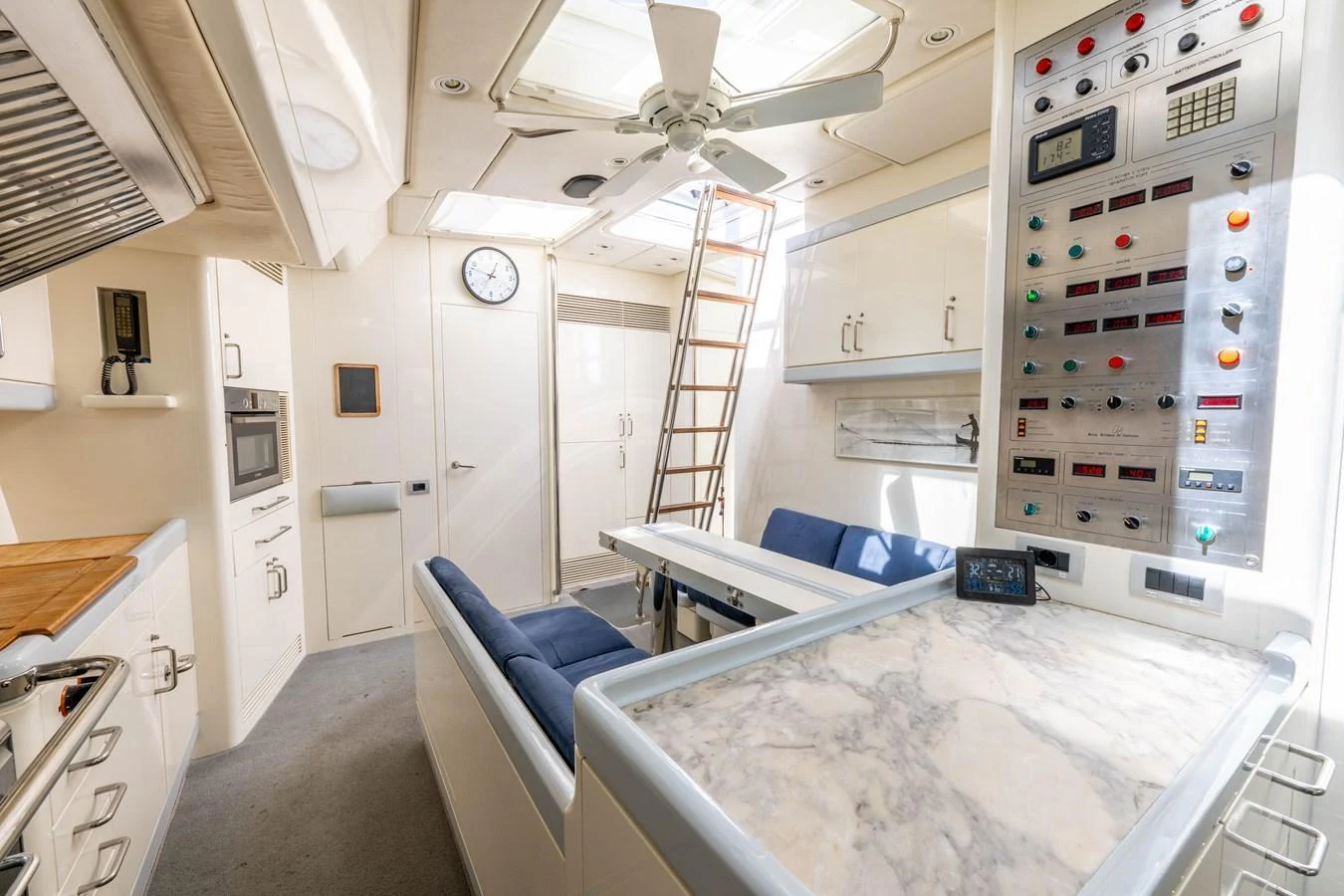 The yacht's galley features modern appliances, a marble countertop, and a cozy dining area. aboard CYCLOS III Yacht for Sale