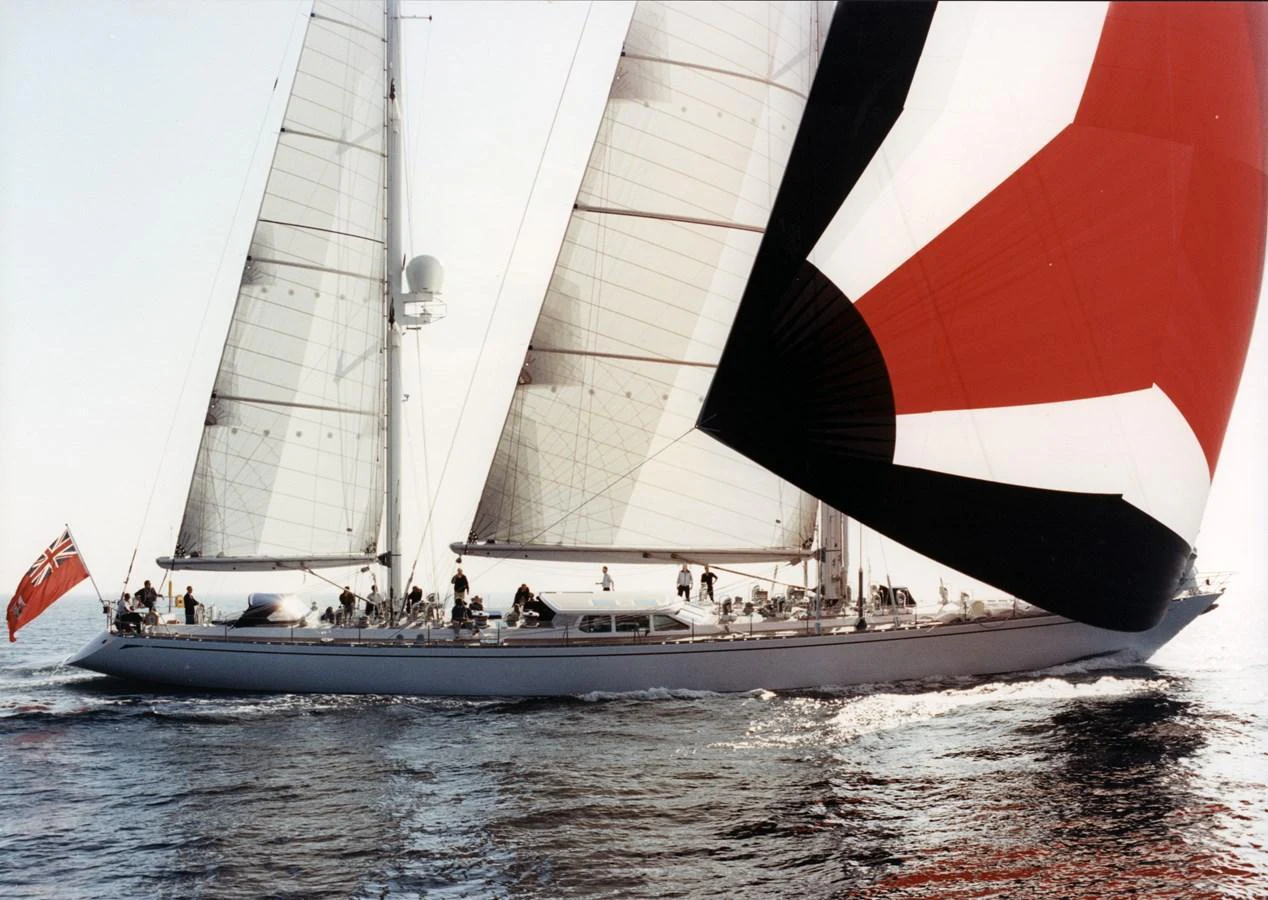 A sleek sailing yacht glides gracefully over calm waters with its sails fully deployed. aboard CYCLOS III Yacht for Sale