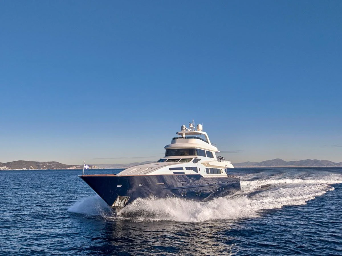 A sleek yacht cruises through the open water under a clear blue sky. aboard CONDOR A Yacht for Sale