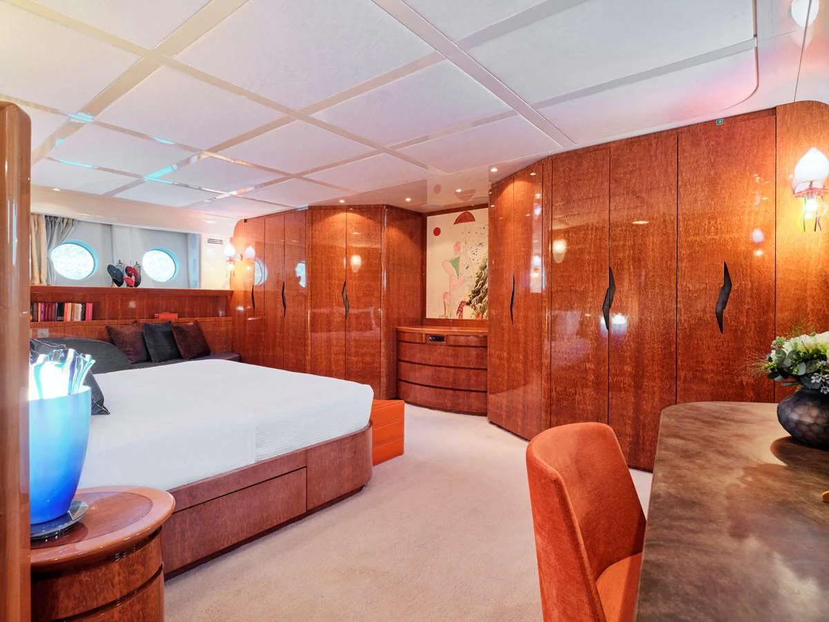 The master stateroom features luxurious wood paneling, a spacious bed, and elegant decor. aboard CONDOR A Yacht for Sale