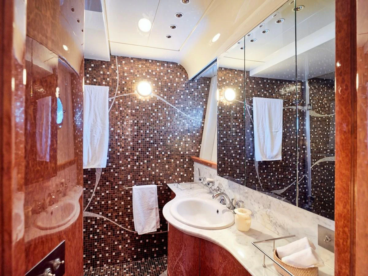 A luxurious yacht bathroom featuring elegant marble countertops and a mosaic-tiled wall. aboard CONDOR A Yacht for Sale