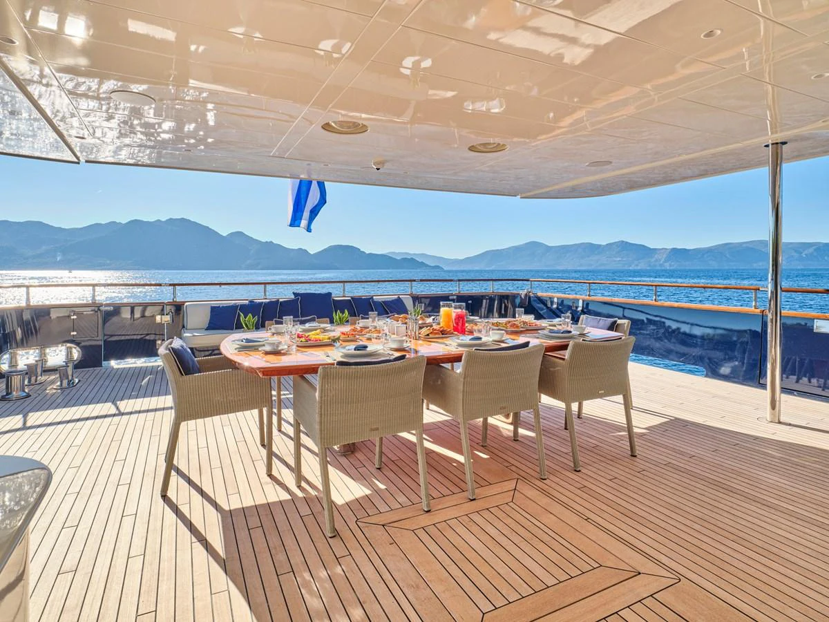 The aft deck features an elegant dining area with a stunning ocean view. aboard CONDOR A Yacht for Sale