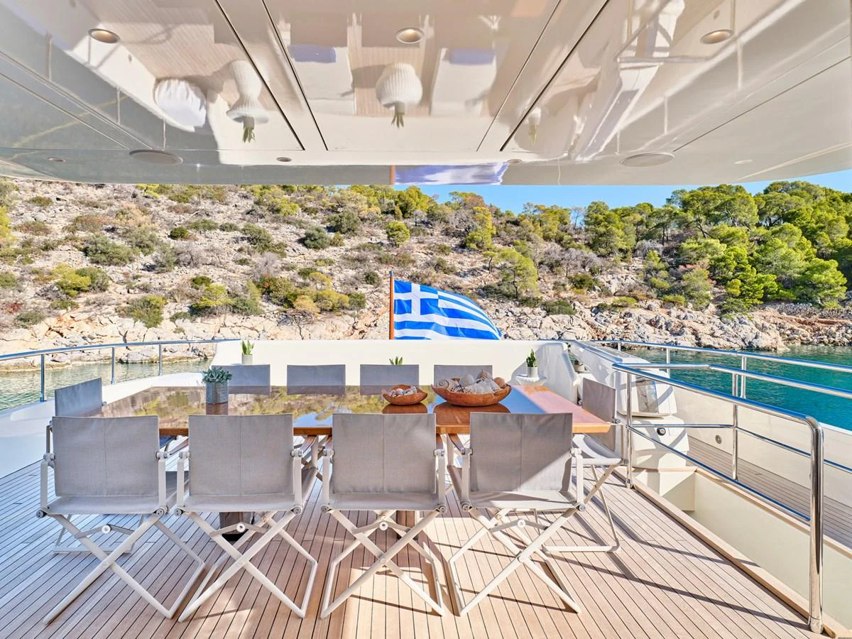 The aft deck features a spacious dining area with a stunning view of the surrounding landscape. aboard CONDOR A Yacht for Sale