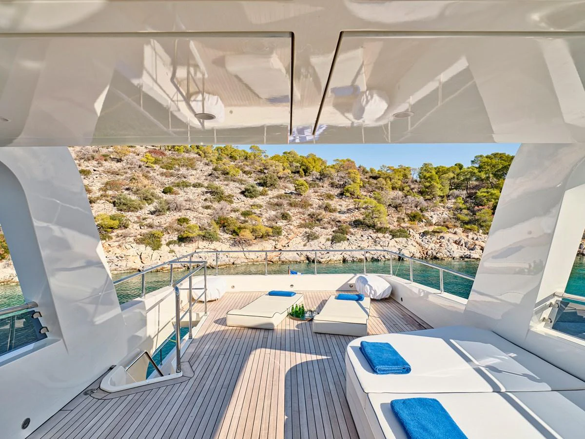 The sundeck offers a serene space with sun loungers and a stunning view of the surrounding landscape. aboard CONDOR A Yacht for Sale
