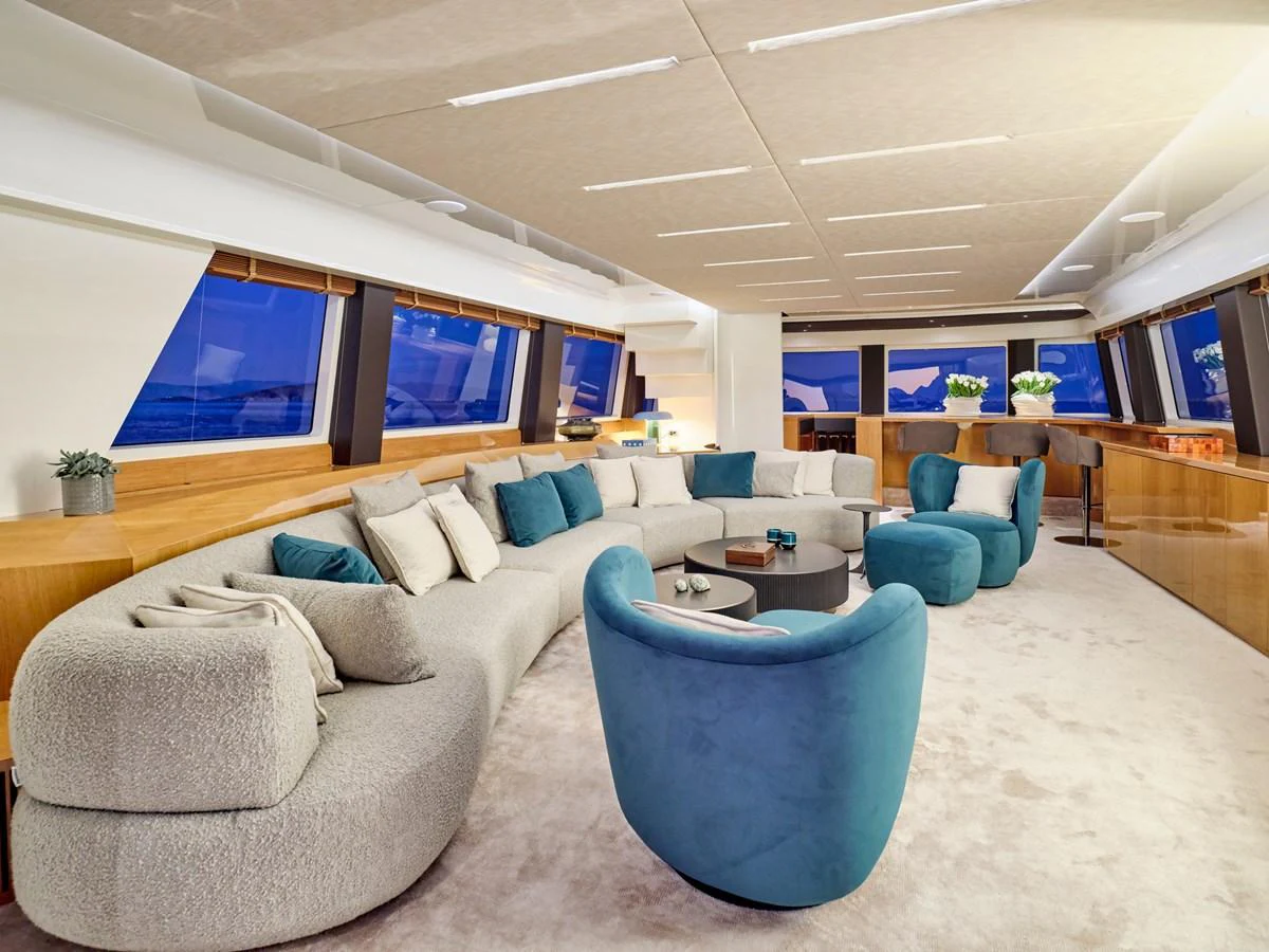 The salon features a modern and spacious seating area with plush furnishings and panoramic windows. aboard CONDOR A Yacht for Sale