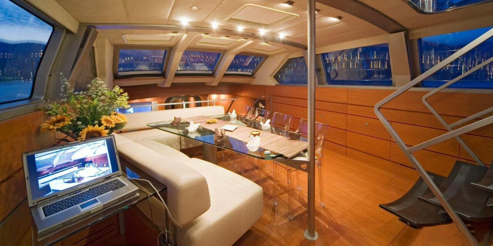 The yacht's salon features a modern design with ample seating and a glass dining table, creating a luxurious and inviting atmosphere. aboard YAMAKAY Yacht for Sale