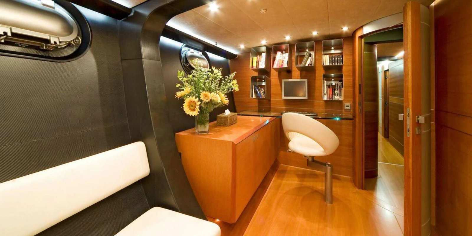 A stylish yacht interior featuring a modern office space with a desk, chair, and built-in shelving. aboard YAMAKAY Yacht for Sale