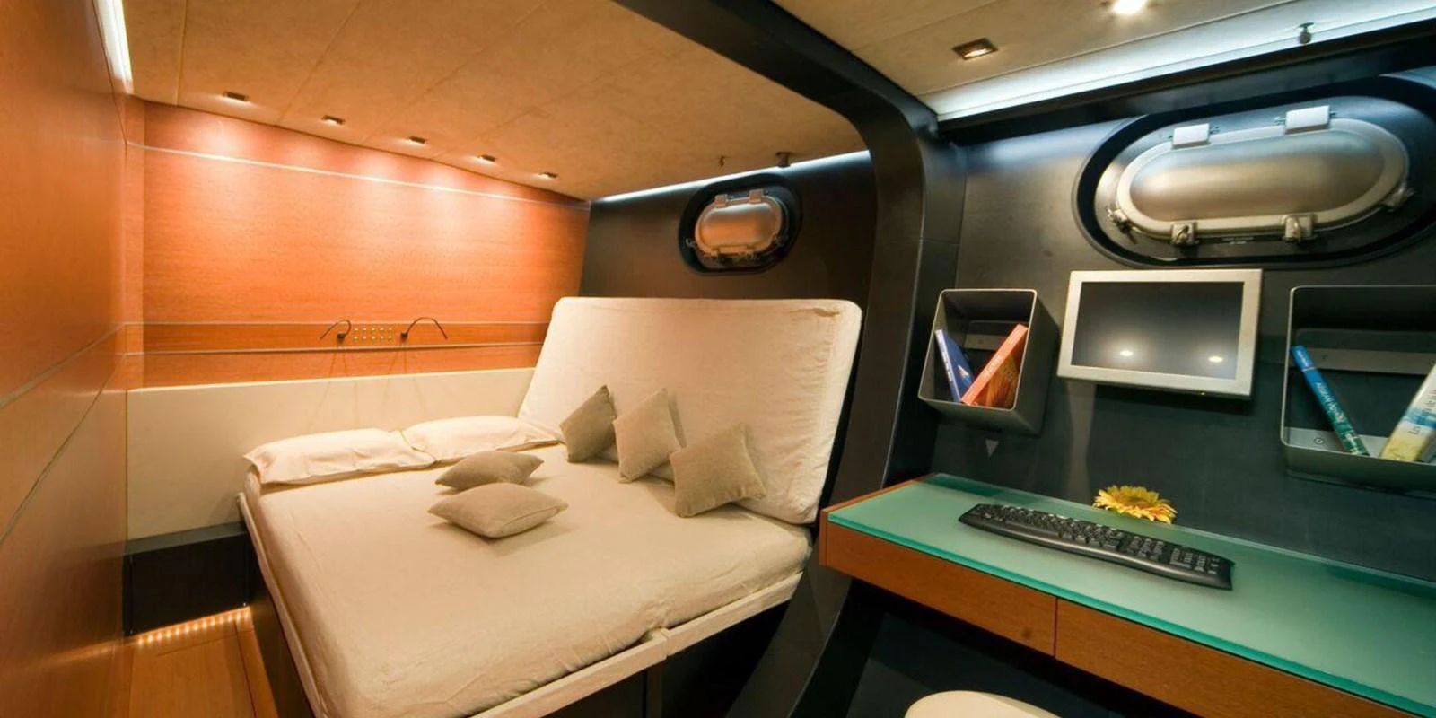 A cozy stateroom featuring a comfortable bed and a work desk with modern amenities. aboard YAMAKAY Yacht for Sale