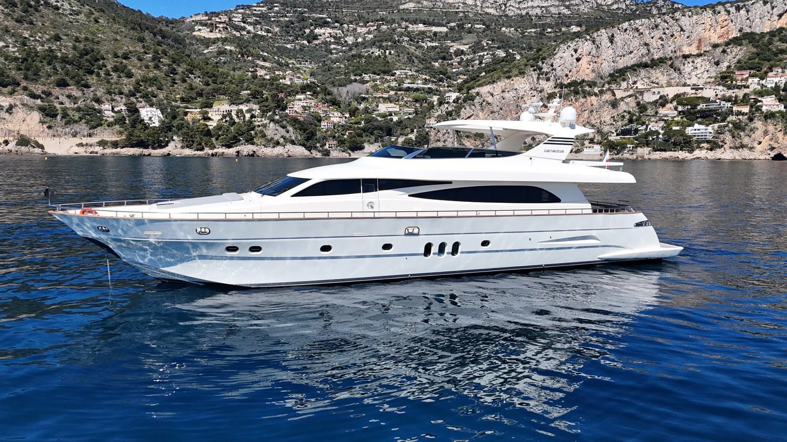 A sleek and modern yacht is anchored in a serene coastal area with picturesque hills in the background. aboard TIME OUT TOGETHER Yacht for Sale