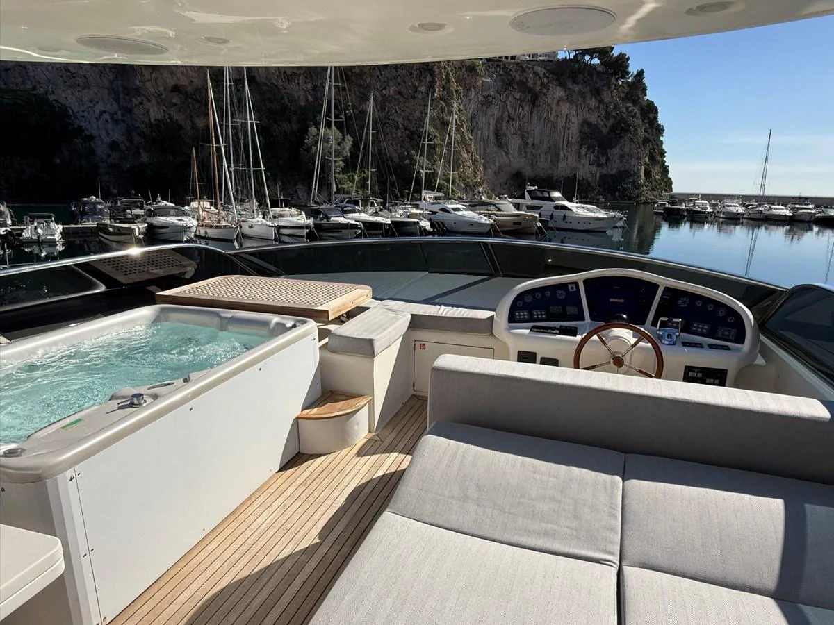 The flybridge features a luxurious hot tub and a comfortable seating area with a view of the marina. aboard TIME OUT TOGETHER Yacht for Sale