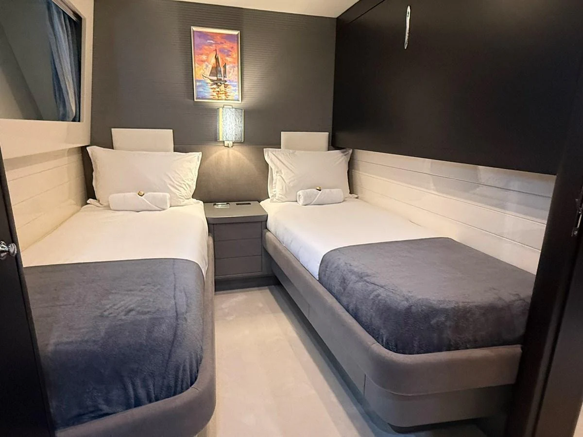 A cozy twin stateroom with modern decor and soft lighting. aboard TIME OUT TOGETHER Yacht for Sale