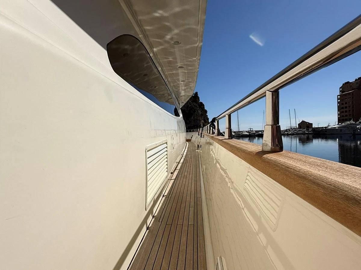 The side deck of the yacht offers a sleek and polished walkway with a view of the marina. aboard TIME OUT TOGETHER Yacht for Sale