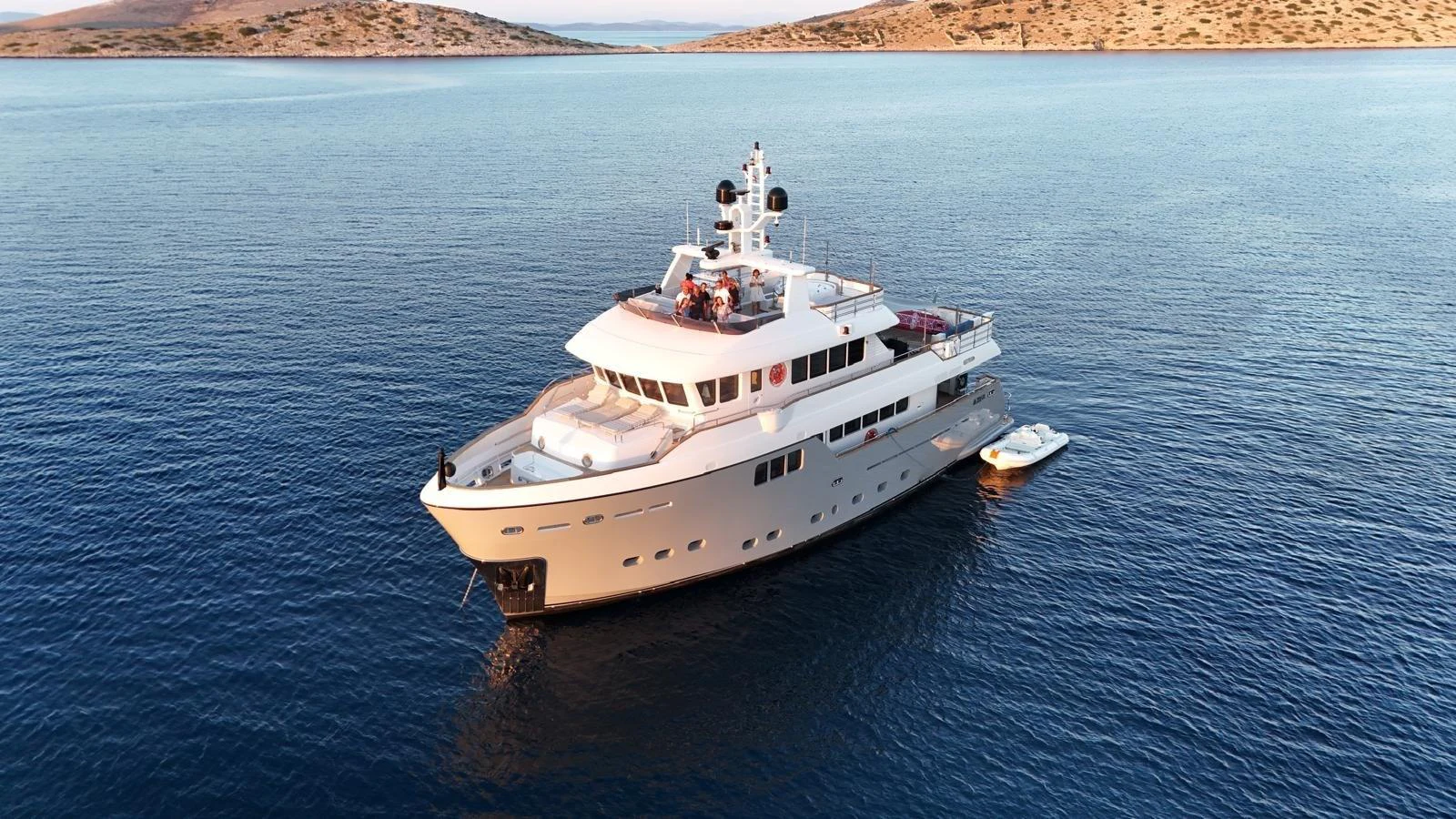 A luxurious yacht glides gracefully on calm waters, surrounded by serene landscapes. aboard GRANIL Yacht for Sale