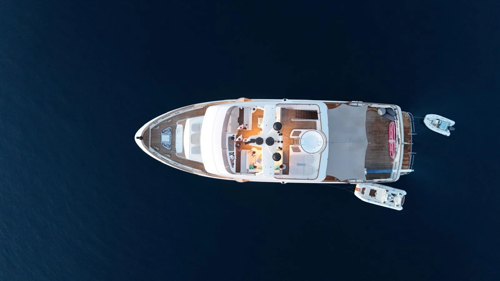 An aerial view of a luxurious yacht cruising on calm waters, showcasing its spacious deck and sleek design. aboard GRANIL Yacht for Sale