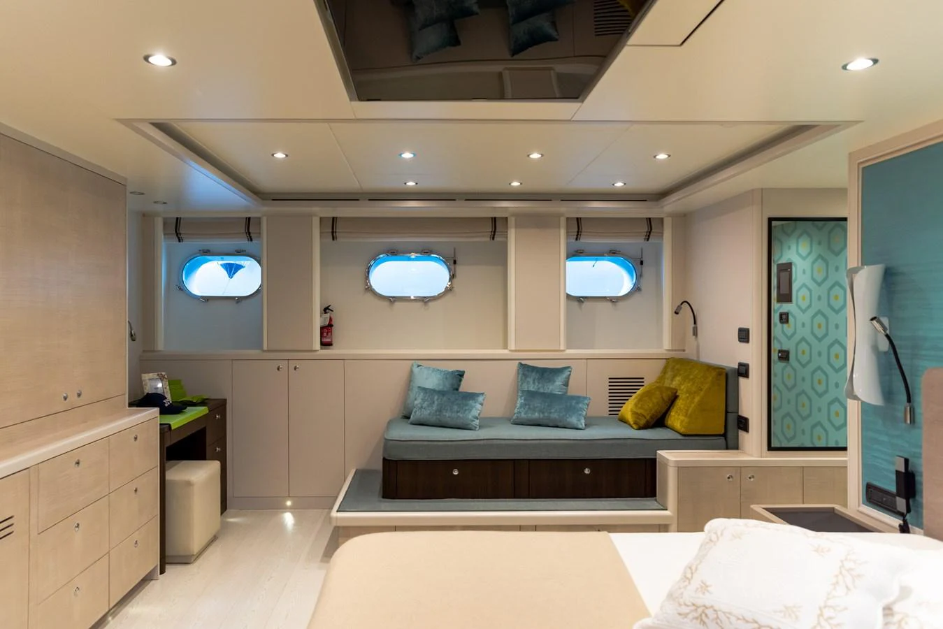 The stateroom features a cozy seating area with porthole windows and modern decor. aboard GRANIL Yacht for Sale