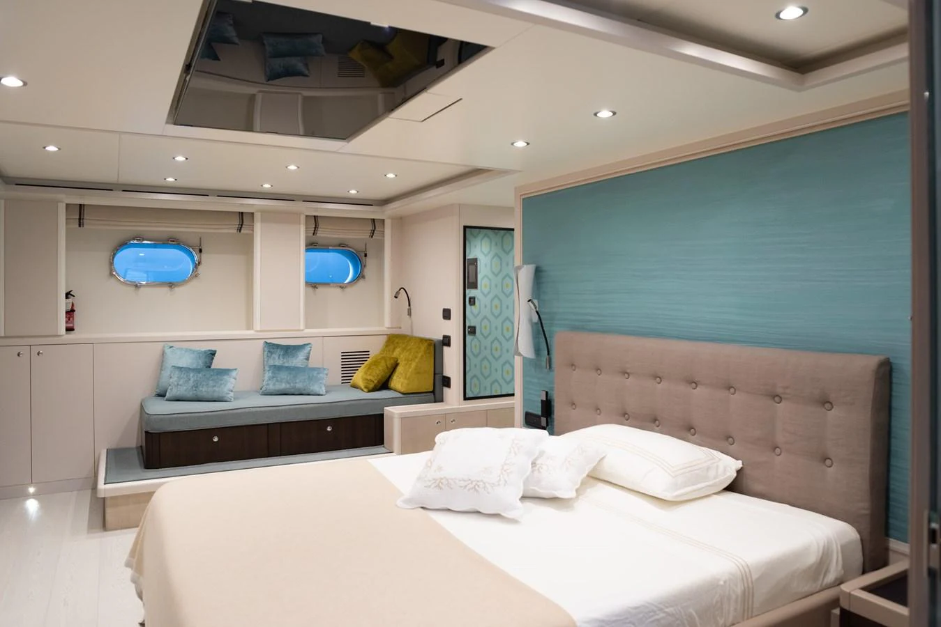 The stateroom features a plush bed, a cozy seating area, and elegant decor with soft lighting. aboard GRANIL Yacht for Sale