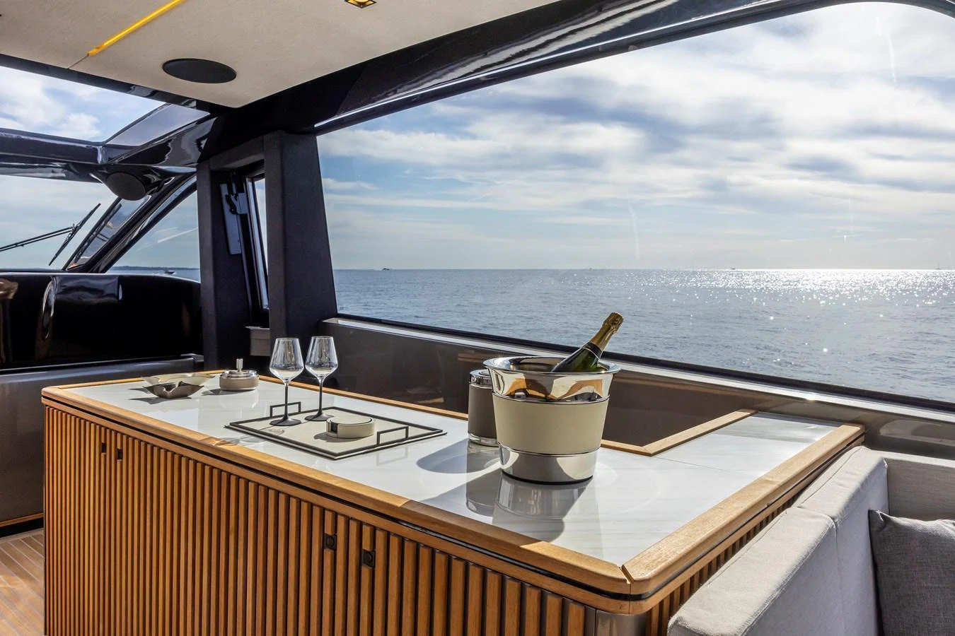 A stylish galley with a view of the sea, featuring a countertop with wine glasses and a bottle of champagne. aboard SEXY ME Yacht for Sale