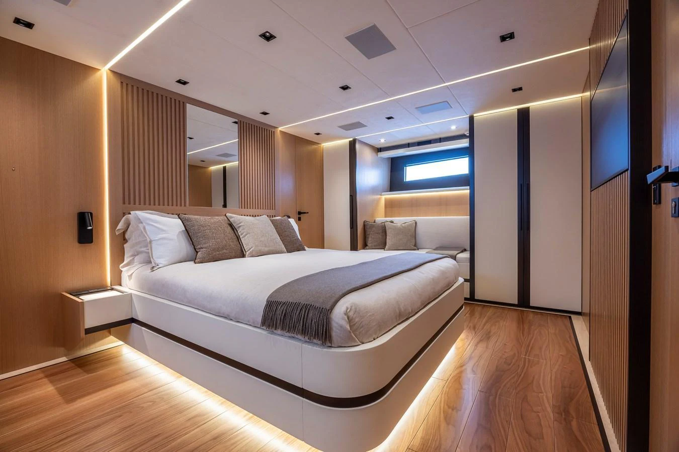 The master stateroom features a luxurious bed with modern wooden accents and ambient lighting. aboard SEXY ME Yacht for Sale