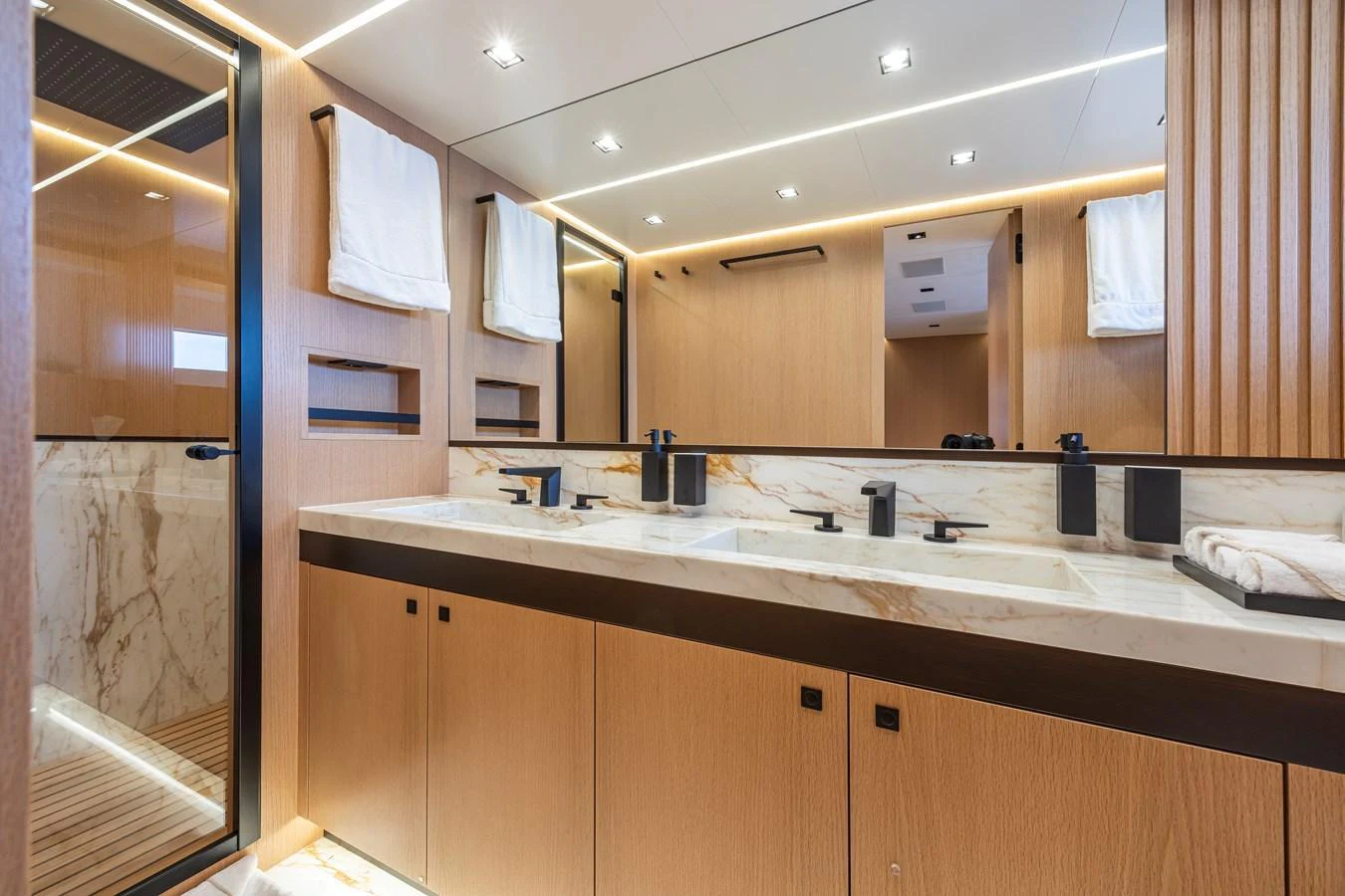 The yacht's bathroom features a luxurious double sink vanity with modern fixtures and elegant marble accents. aboard SEXY ME Yacht for Sale