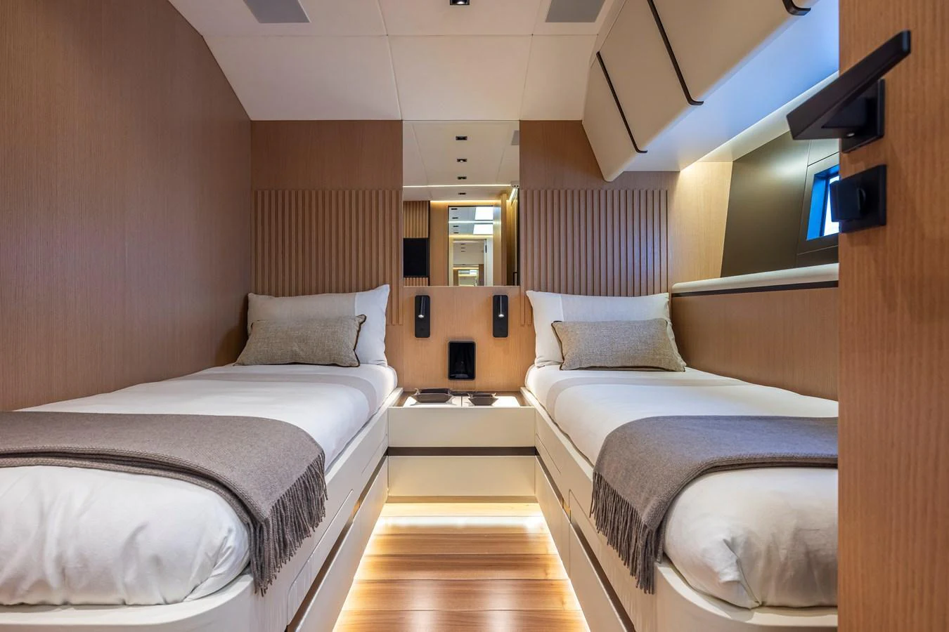 The twin stateroom features two single beds with elegant bedding and warm wood finishes, creating a cozy and inviting atmosphere. aboard SEXY ME Yacht for Sale