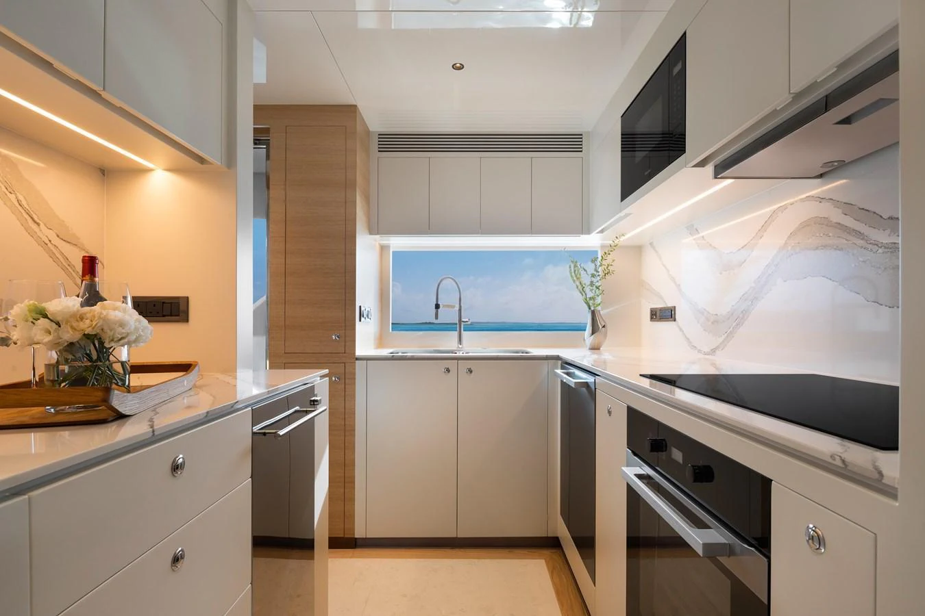 The galley features modern appliances and a stunning ocean view through the window. aboard AVELINE Yacht for Sale