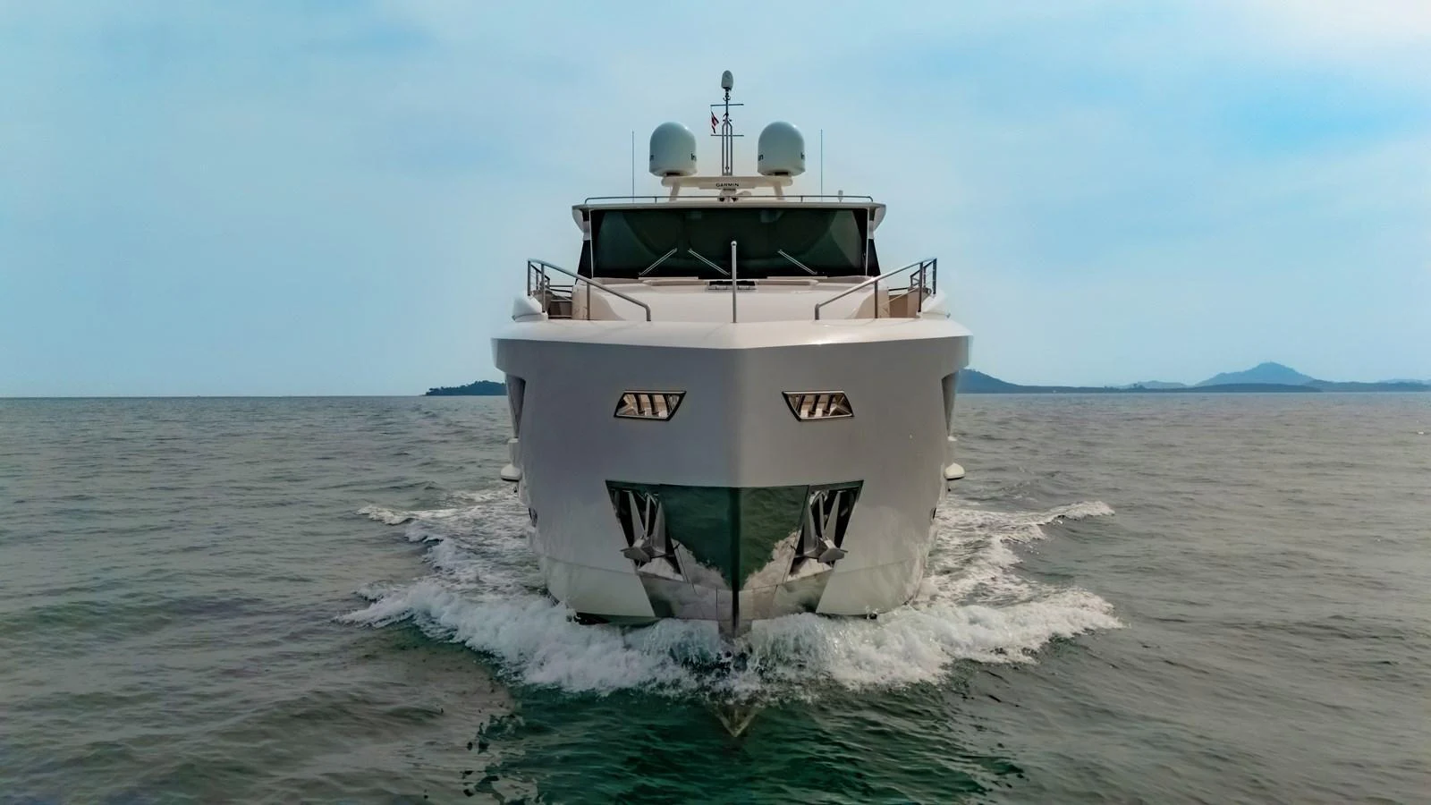 A luxurious yacht cruises forward on calm waters, showcasing its sleek design and powerful presence. aboard AVELINE Yacht for Sale