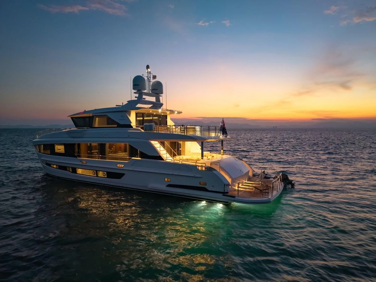 A luxurious yacht is beautifully illuminated at sunset, showcasing its elegant design and inviting ambiance. aboard AVELINE Yacht for Sale