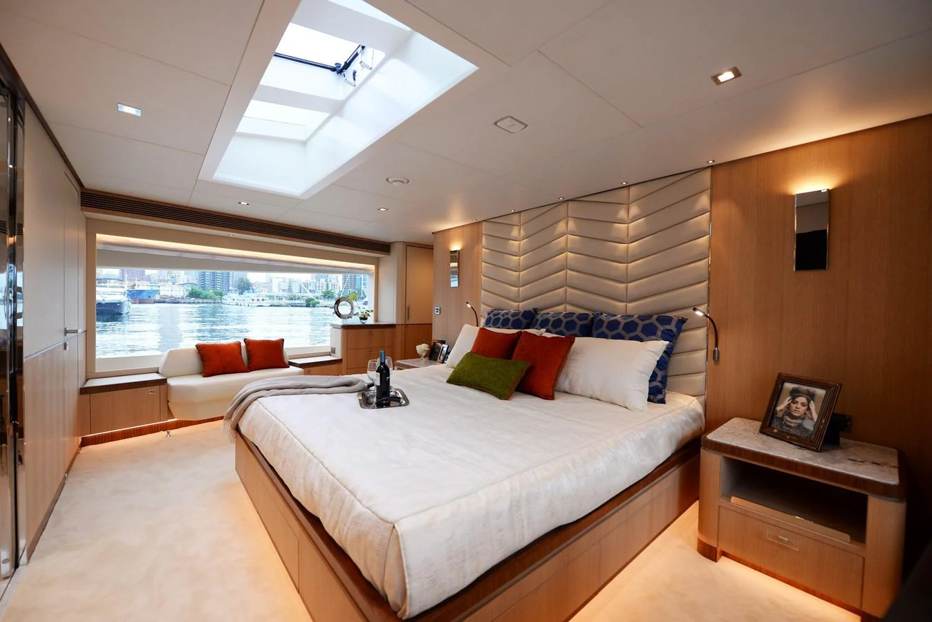 The master stateroom features a luxurious bed with plush pillows, a skylight, and a serene view of the water. aboard AQUA LIFE Yacht for Sale