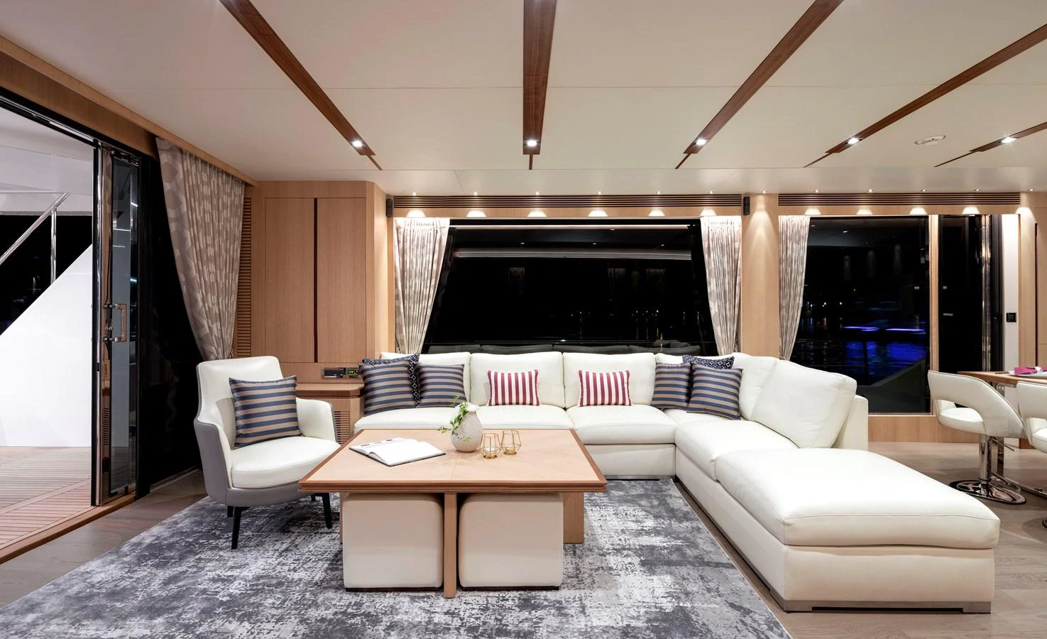 The salon features a spacious and elegantly furnished seating area with large windows offering a view of the outside. aboard AQUA LIFE Yacht for Sale
