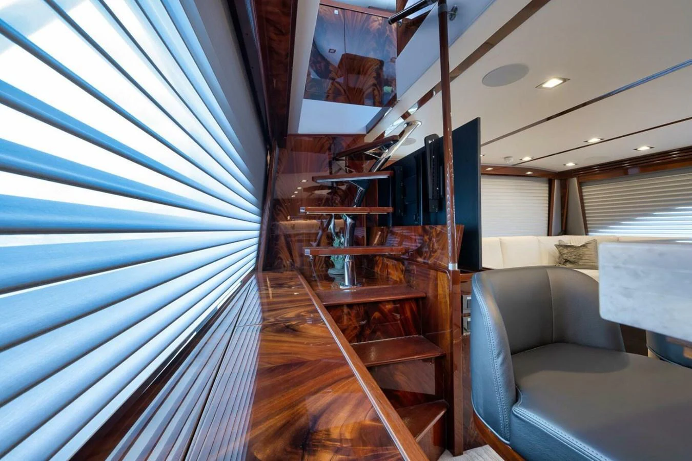 The yacht's interior features a luxurious staircase with rich wood finishes and comfortable seating. aboard NIKKI BELLA Yacht for Sale