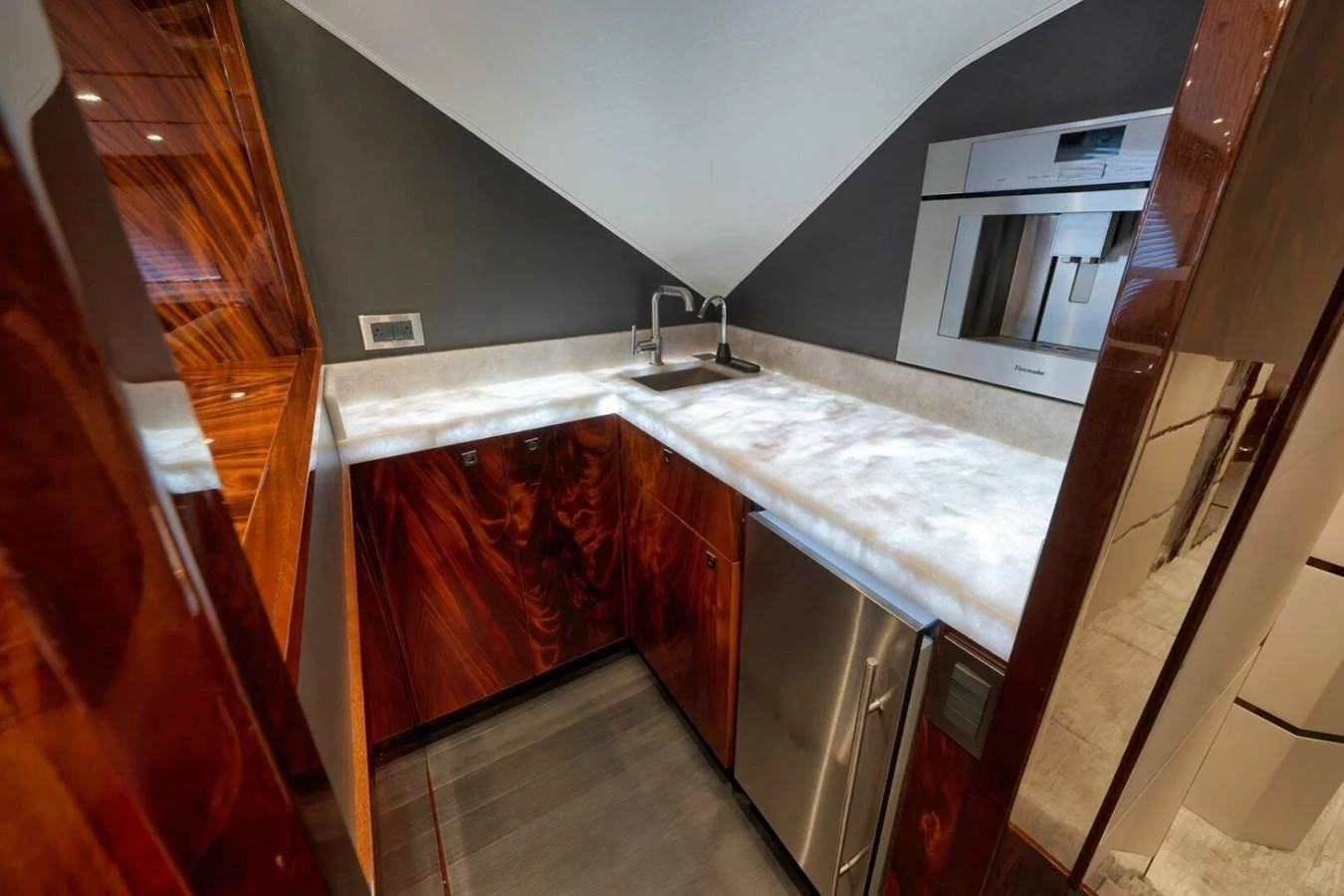 The yacht's galley features sleek modern appliances and rich wood cabinetry. aboard NIKKI BELLA Yacht for Sale