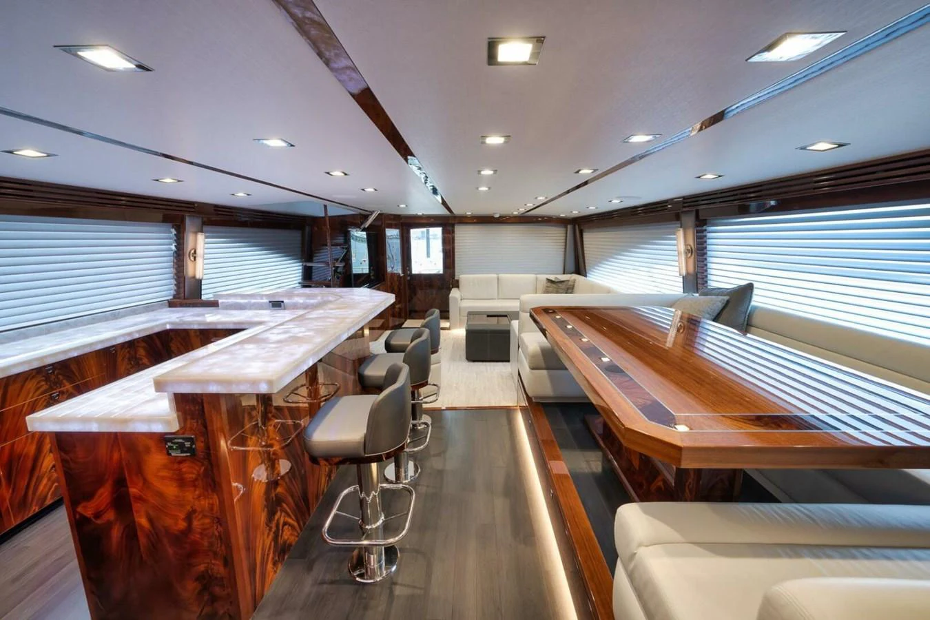 The salon features luxurious seating, a stylish bar, and elegant wood finishes. aboard NIKKI BELLA Yacht for Sale