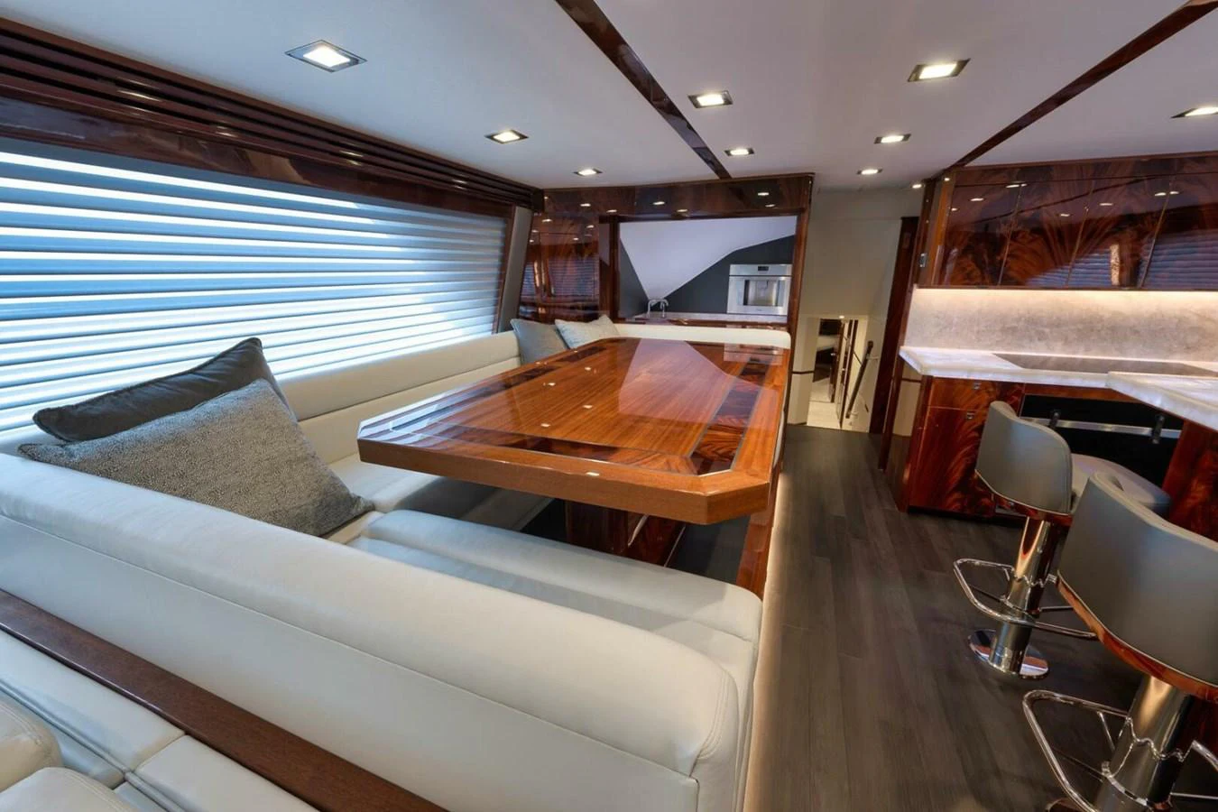 The yacht's salon features a luxurious seating area with a polished wooden table and modern lighting. aboard NIKKI BELLA Yacht for Sale