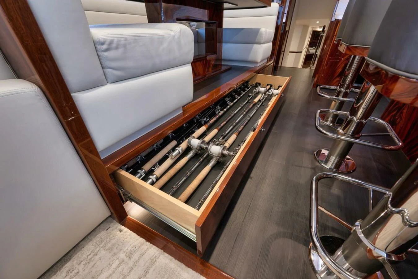 The image showcases a hidden storage drawer with fishing rods neatly organized inside. aboard NIKKI BELLA Yacht for Sale