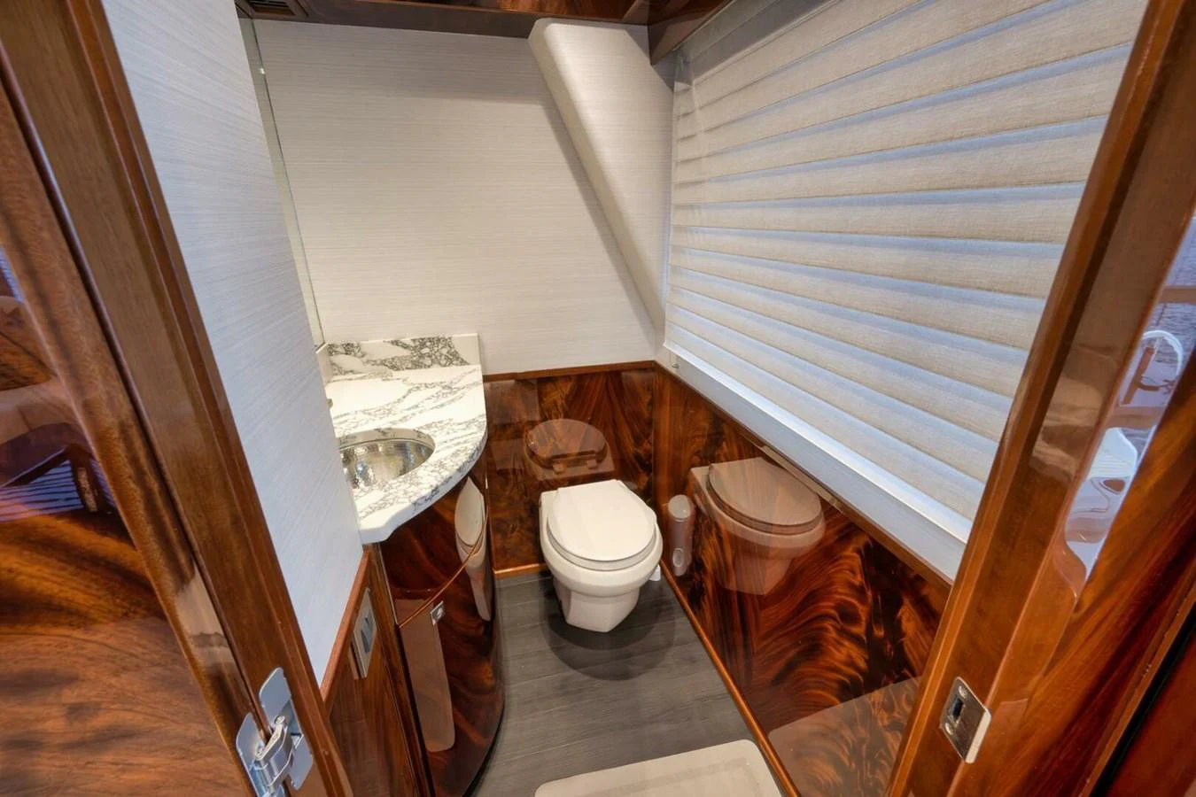 The yacht's bathroom features elegant wood paneling and a modern sink with a marble countertop. aboard NIKKI BELLA Yacht for Sale