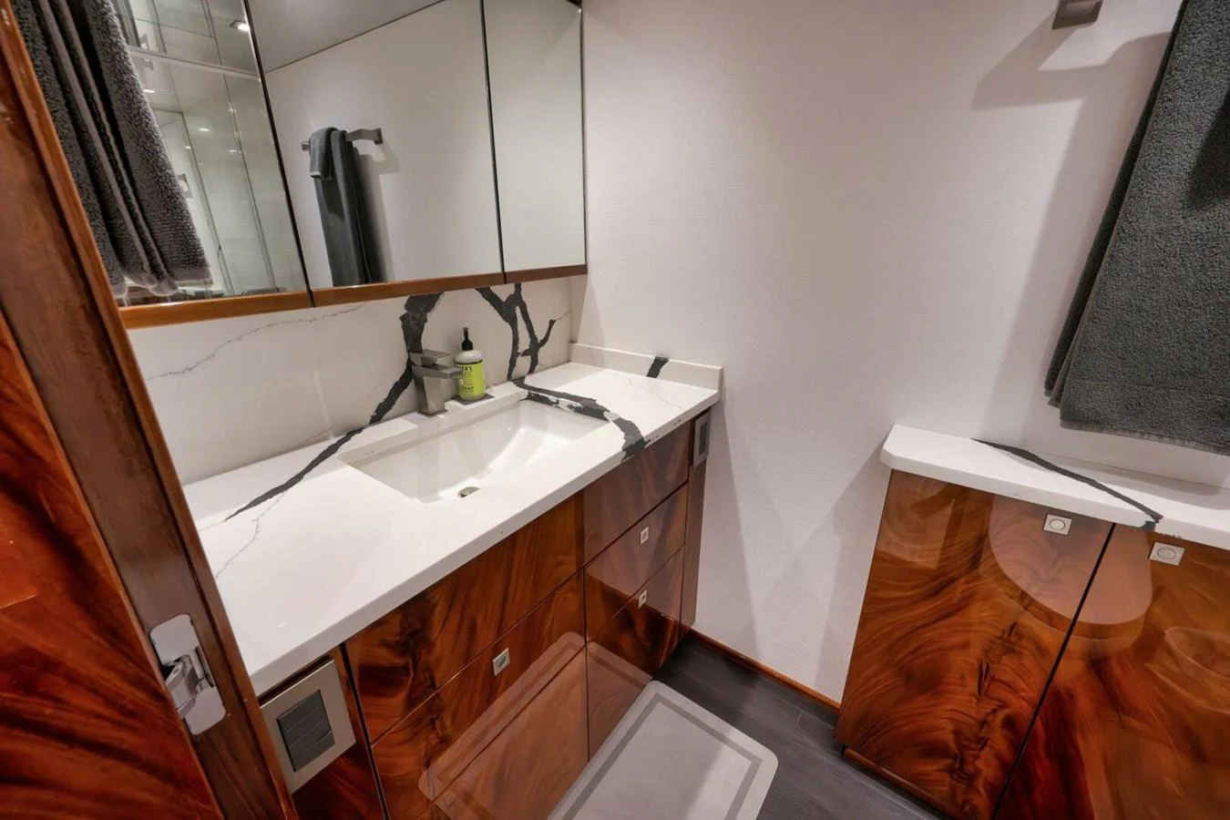 The yacht's bathroom features a sleek design with a modern sink and elegant wood accents. aboard NIKKI BELLA Yacht for Sale