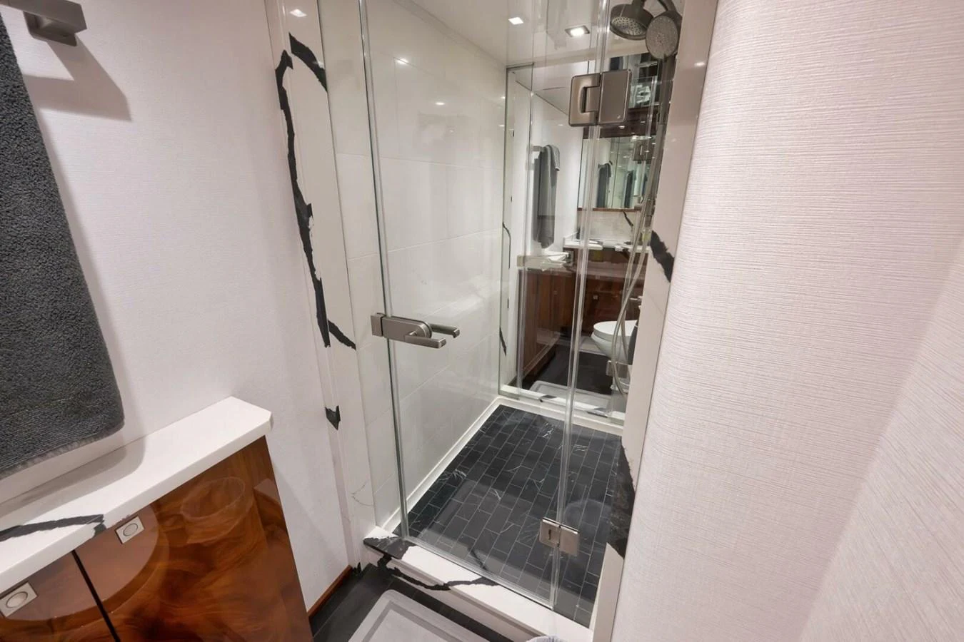 A modern yacht bathroom with a glass-enclosed shower and sleek fixtures. aboard NIKKI BELLA Yacht for Sale