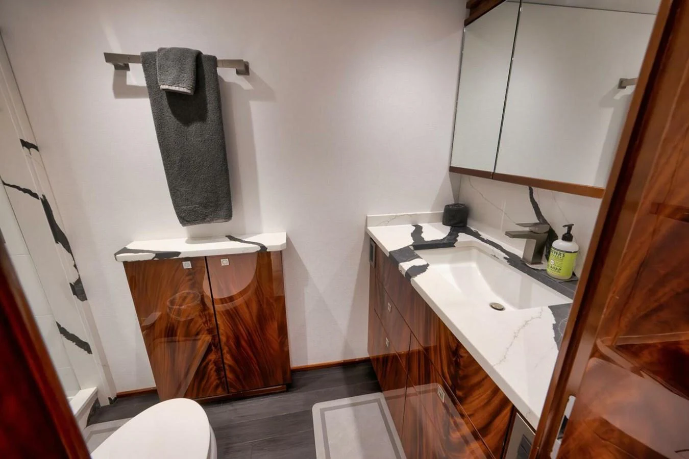 A luxurious yacht bathroom featuring elegant wood cabinetry and a sleek, modern sink. aboard NIKKI BELLA Yacht for Sale
