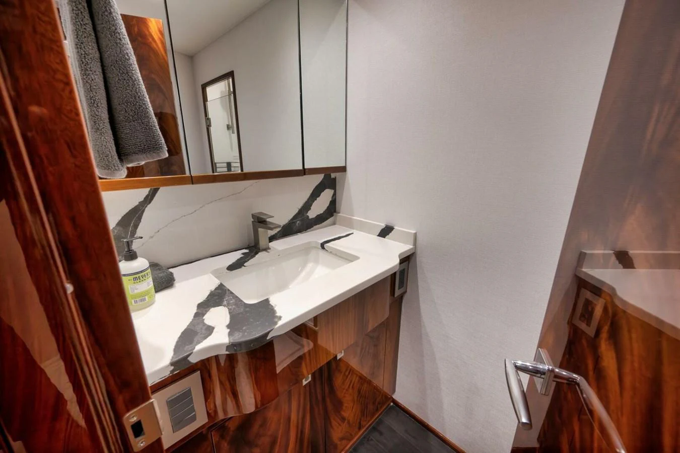 The yacht's bathroom features a sleek, modern design with a marble countertop and wooden accents. aboard NIKKI BELLA Yacht for Sale