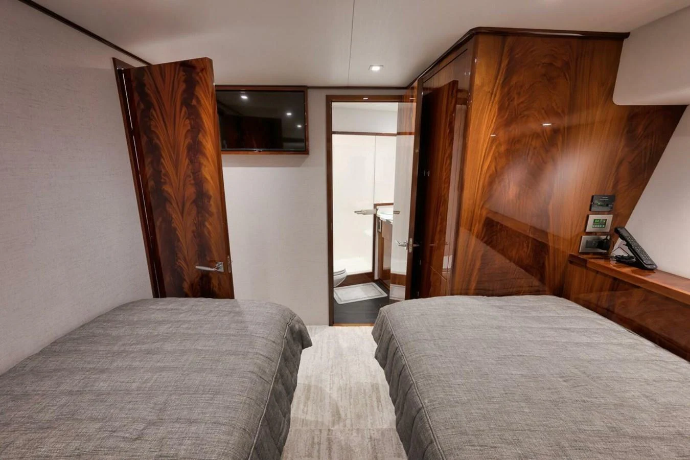 A cozy guest cabin featuring twin beds and elegant wood paneling. aboard NIKKI BELLA Yacht for Sale