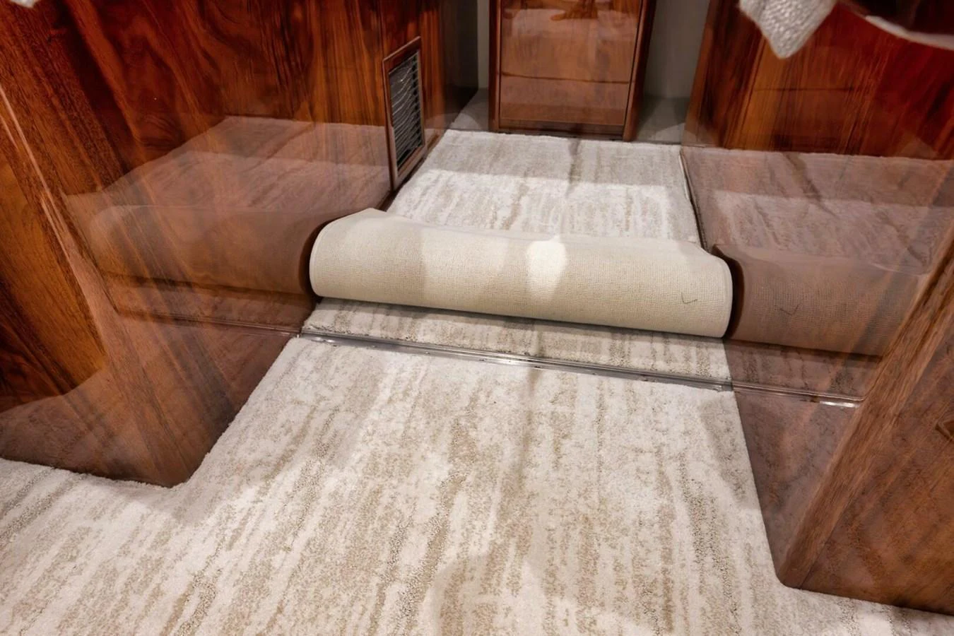 The image showcases a luxurious interior space with rich wooden finishes and plush carpeting. aboard NIKKI BELLA Yacht for Sale